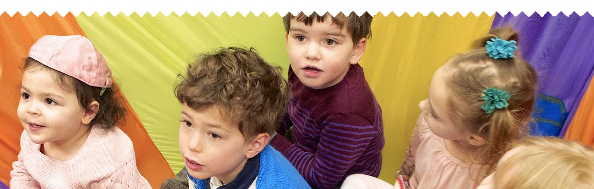 Children at Tot Shabbat, on colorful parachute
